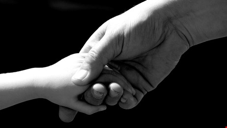 En vuxenhand håller i en barnhand