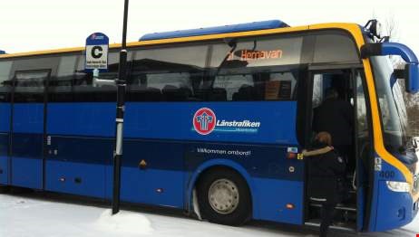 En person kliver på en blå buss.