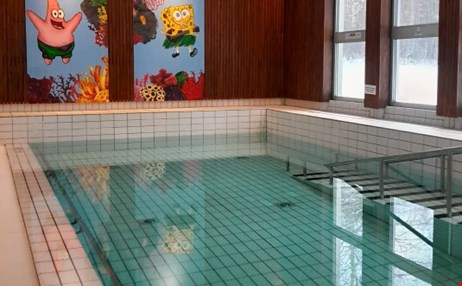 vuxna och barn som badar i terapibassängen.